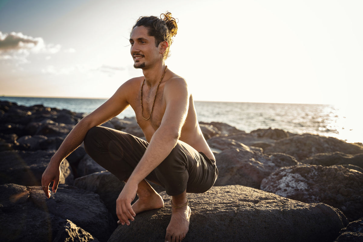 Mann macht am Strand Yoga