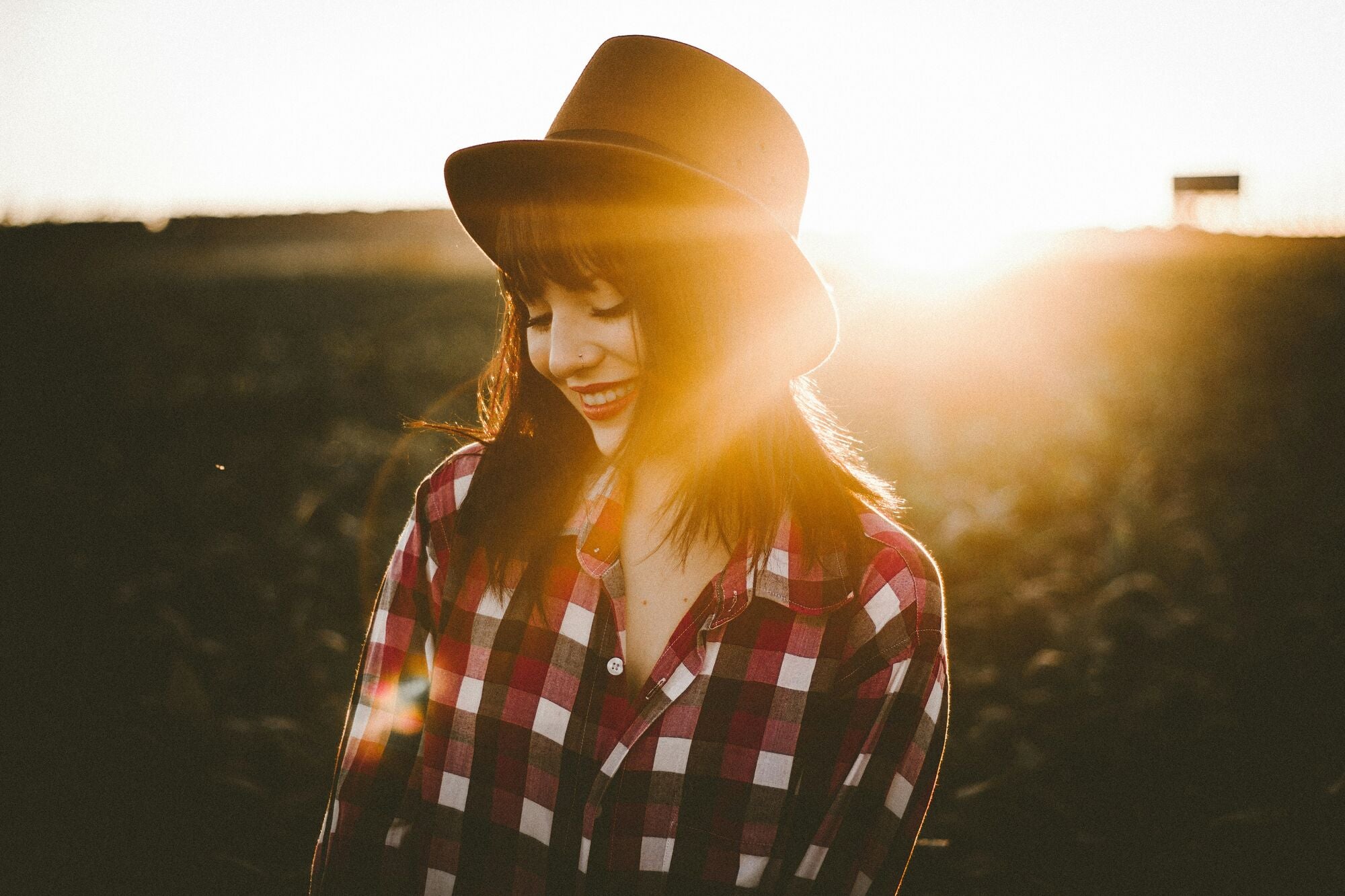 Frau im Sonnenuntergang mit Hut