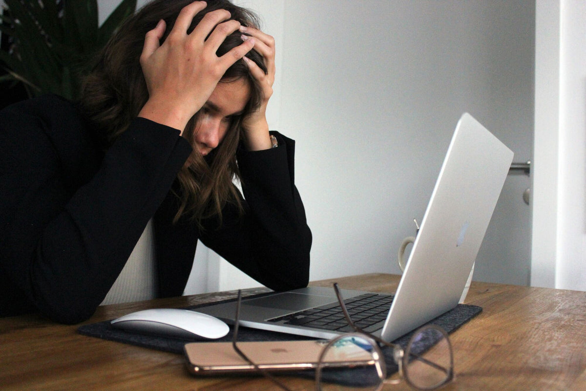 Frau beugt sich gestresst über ihren Laptop
