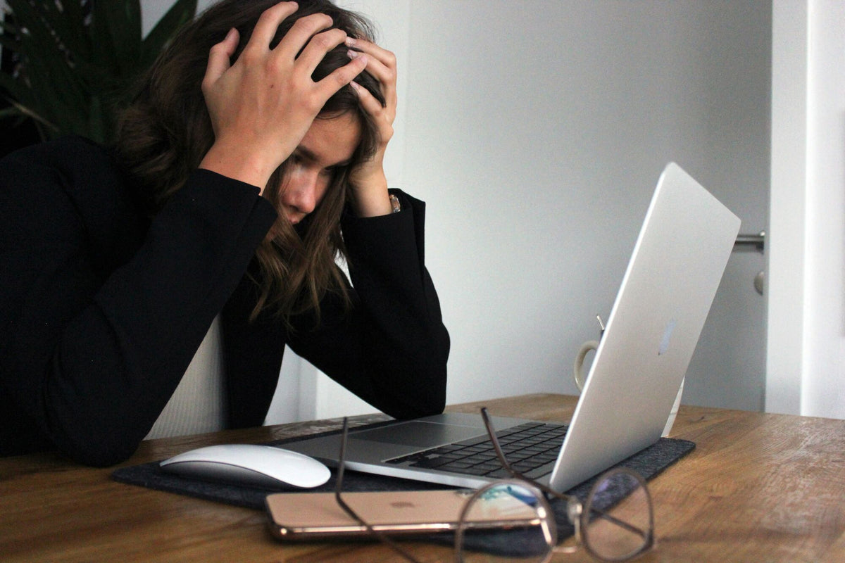 Frau beugt sich gestresst über ihren Laptop