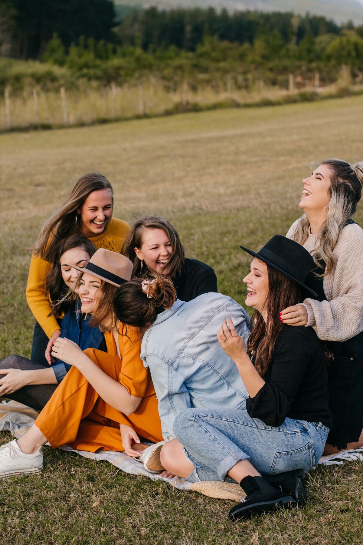 Frauen sitzen auf einer Picknickdecke und lachen