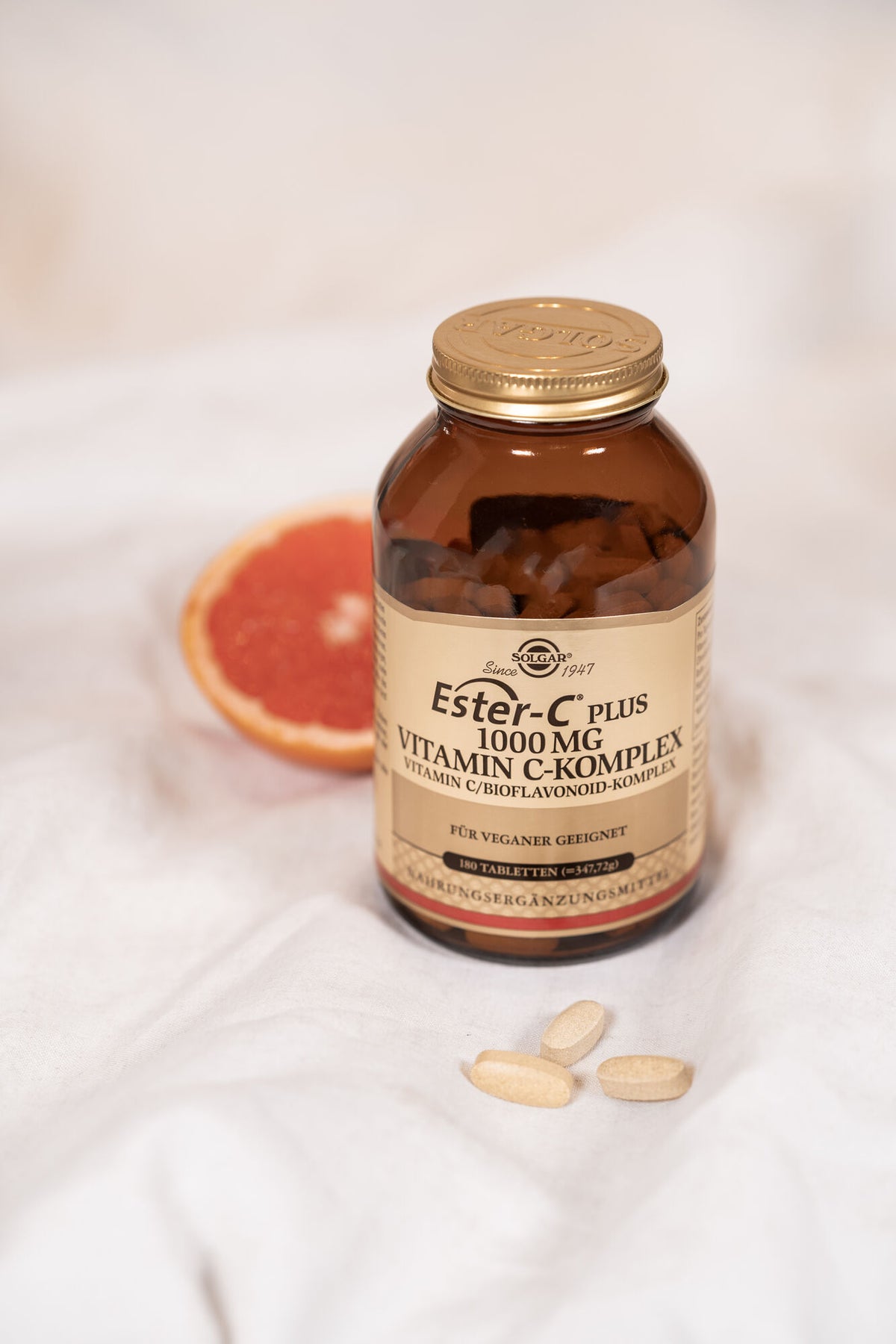 Solgar Ester-C Tabletten vor einer Grapefruit